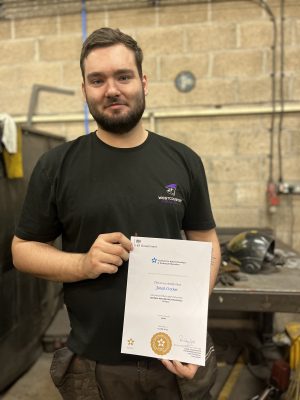 Jonah Crocker holding his apprenticeship certificate
