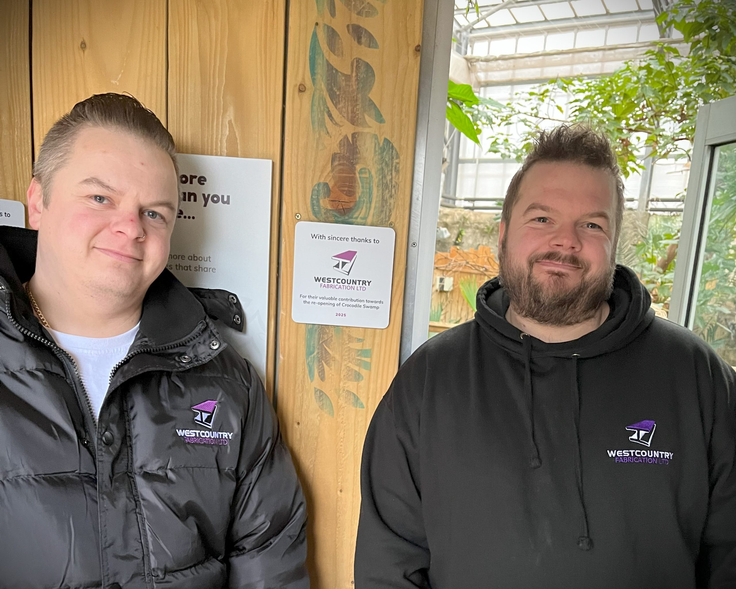 Steel workers smiling next to a sign that say 'With Sincere thanks to Westcountry Fabrication Ltd for their valuable contribution to the re-opening of Crocodile Swamp